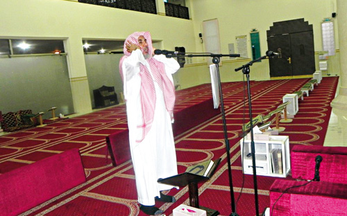 صورة لأحد المسلمين يؤذن للصلاة من داخل المسجد.