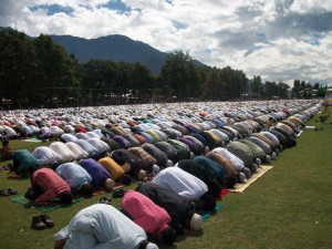 صورة لمجموعة من المسلمين يؤدون صلاة العيد في الساحة.